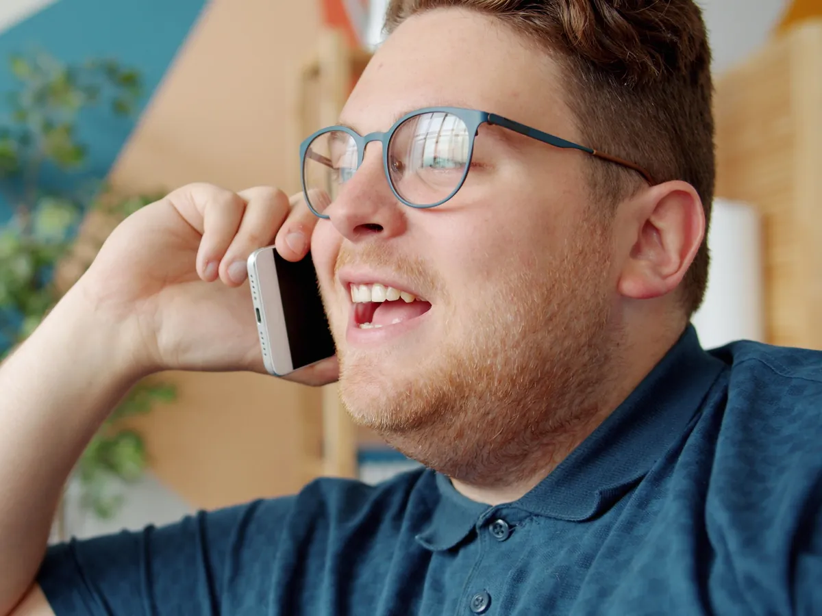 Homme souriant qui répond à un appel sur son téléphone
